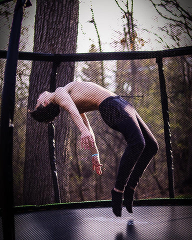 Teenage boy doing a backflip on a Jumpflex trampoline