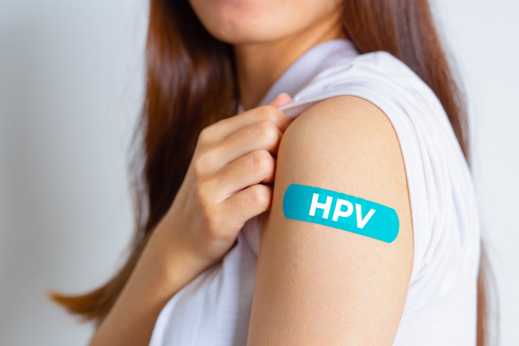 Poză cu femeie cu bandaj pe braț cu inscripția HPV.