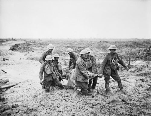 A team of stretcher bearers struggle through deep mud to carry a wounded man to safety near Boesinghe on 1 August 1917 during the Third Battle of Ypres.