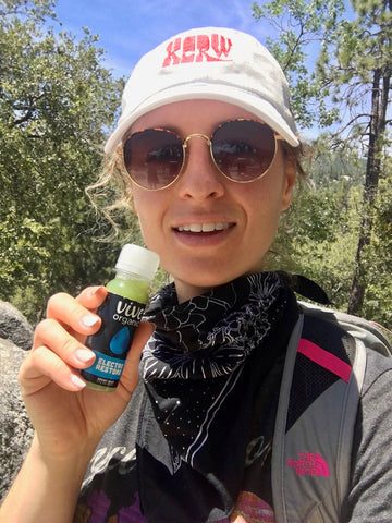 Shannon outdoors with a bottle of Electro Restore