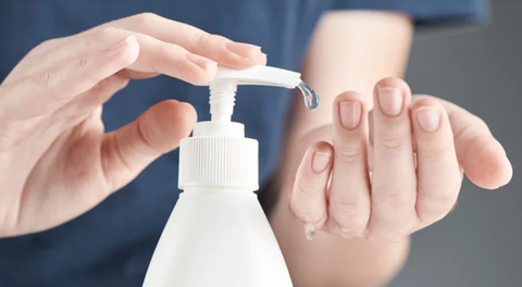 a female person using hand sanitizer
