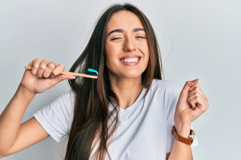 a happy girl holding a toothbrush