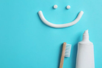 toothpaste and toothbrush with a drawn smile above