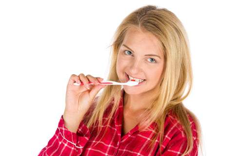 a blonde woman brushing her teeth