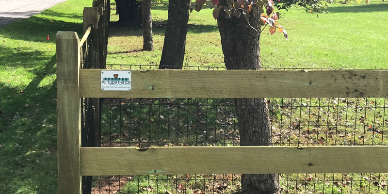 Wood fence with an All Type Fence placard on it