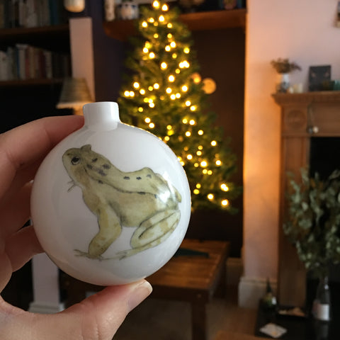 frog bauble in front of a twinkly Christmas tree