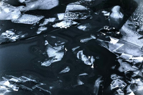 blue black water with a thin layer of ice on top