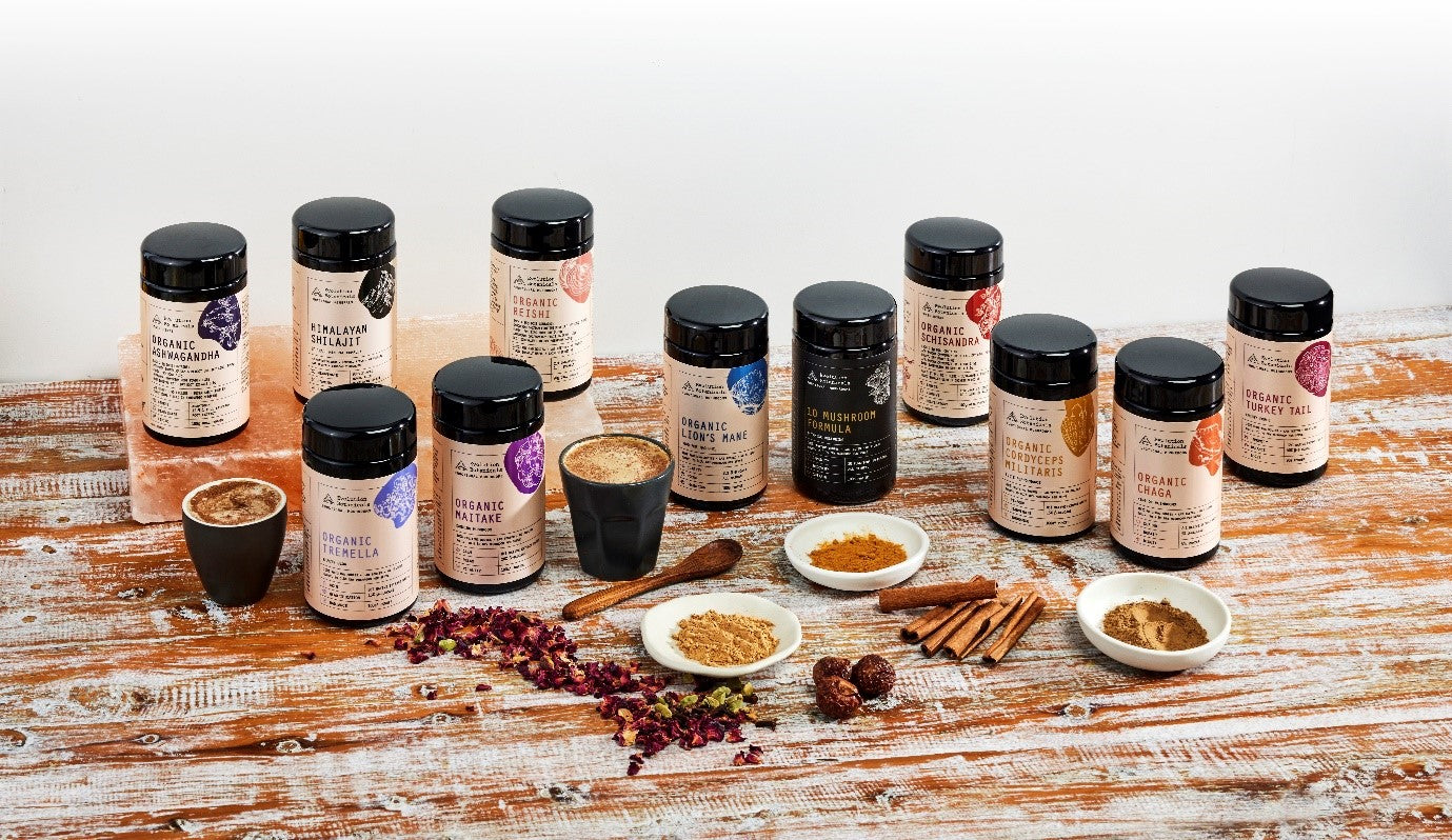 Evolution Botanicals range displayed on a wooden table surrounded by various forms of ingredients and utensils