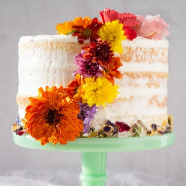 A modern take on a beloved Christmas dessert: a Bibingka Naked Cake decorated with colorful flowers (Source: Egg Marks The Spot)