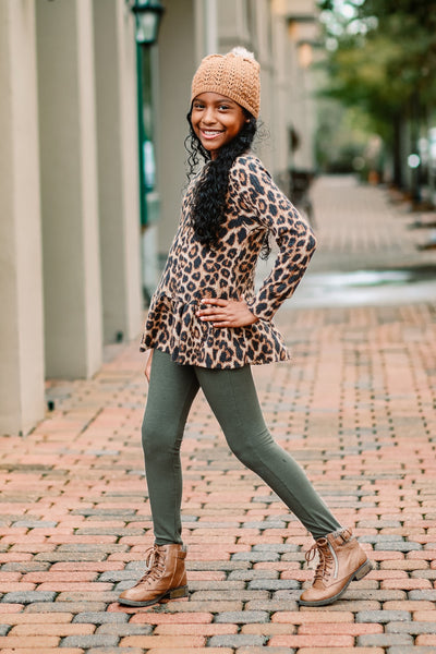 Youth wearing ribbed leggings and peplum top with beanie and boots