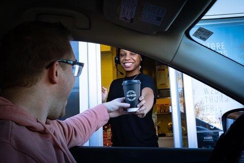 A coffee cup is presented to a customer in the Drive-Thru at Town Center Cold Pressed on General Booth Blvd near the Ocean Lakes neighborhood.