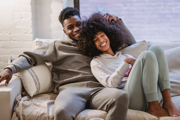 a couple laying down on the couch relaxing