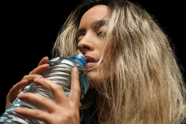 A woman holding on to a blue bottle 