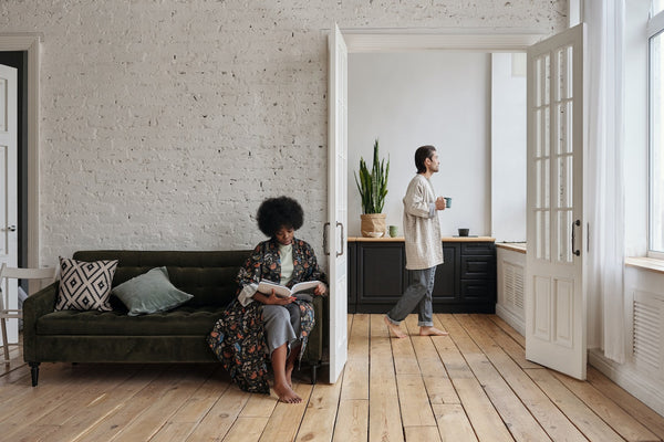 A woman reading a book on her couch