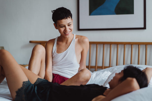 Two women laying down in bed