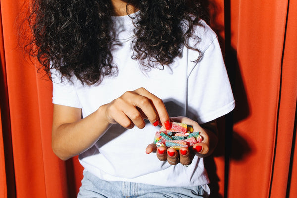 A woman holding CBD gummies in her hand