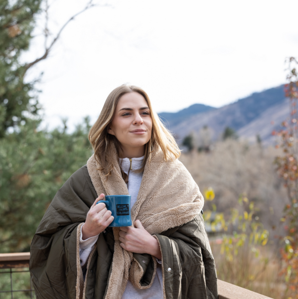 woman wearing a heated blanket in camping