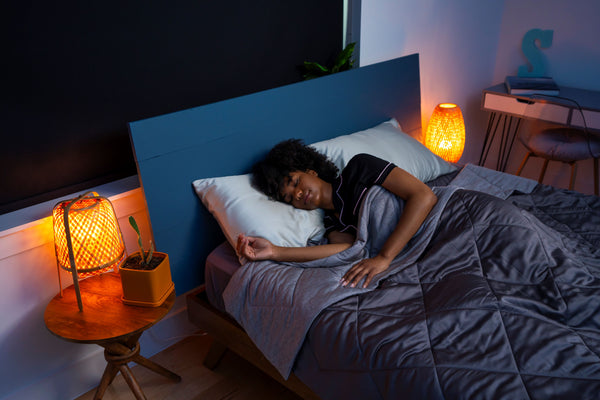 A woman sleeps under a cooling comforter