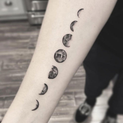 Moon phases tattoo located on the sternum