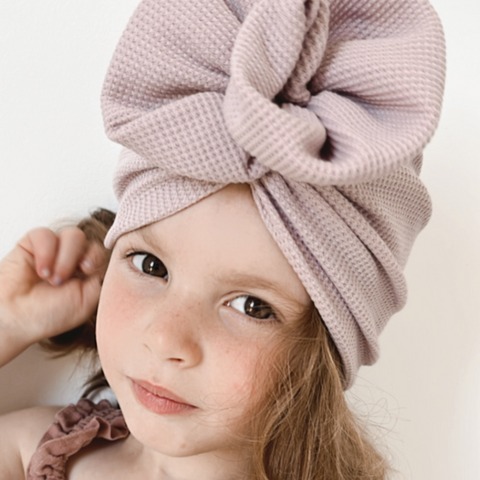 little Girl wearing dusty pink turban keeping her hair out of her face