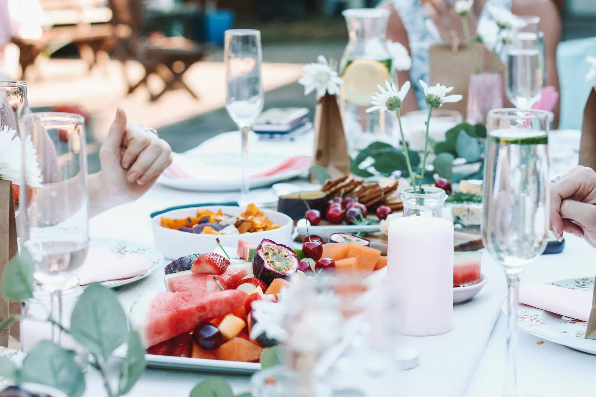 Table set with fruit, flowers, and glasses