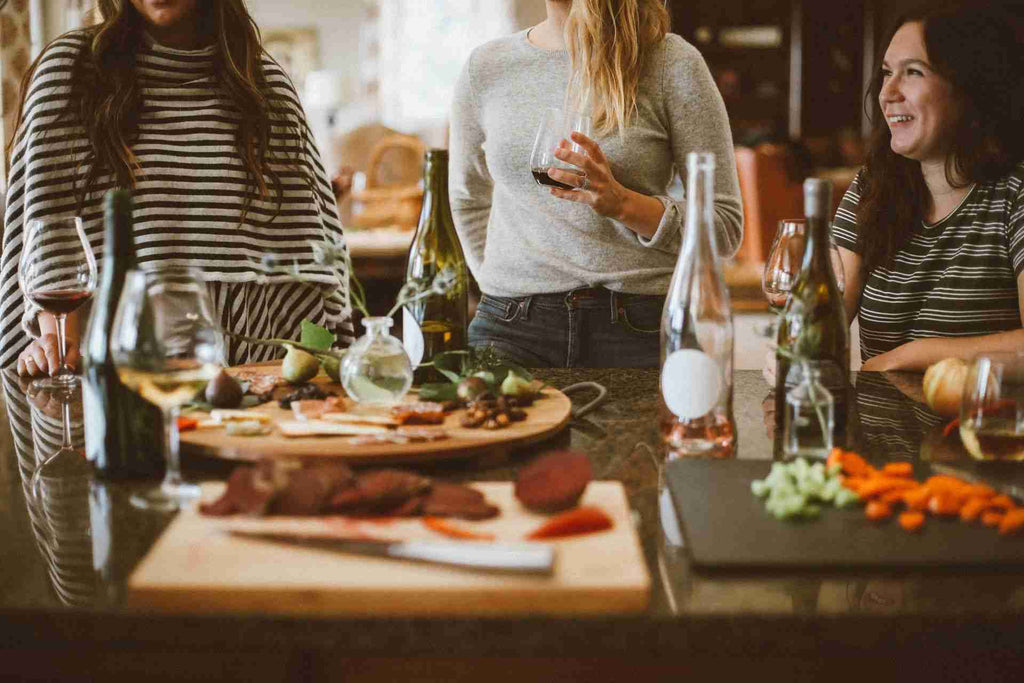 cropped photo of guests enjoying wine at a dinner party while having a conversation