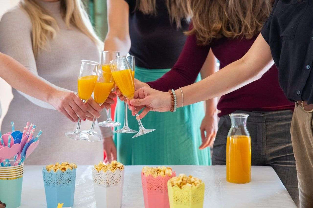 guests making a toast at a graduation party with mocktail beverages