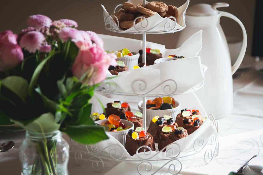 Sweet treats, flowers, and tea set up for a Mother’s Day tea party