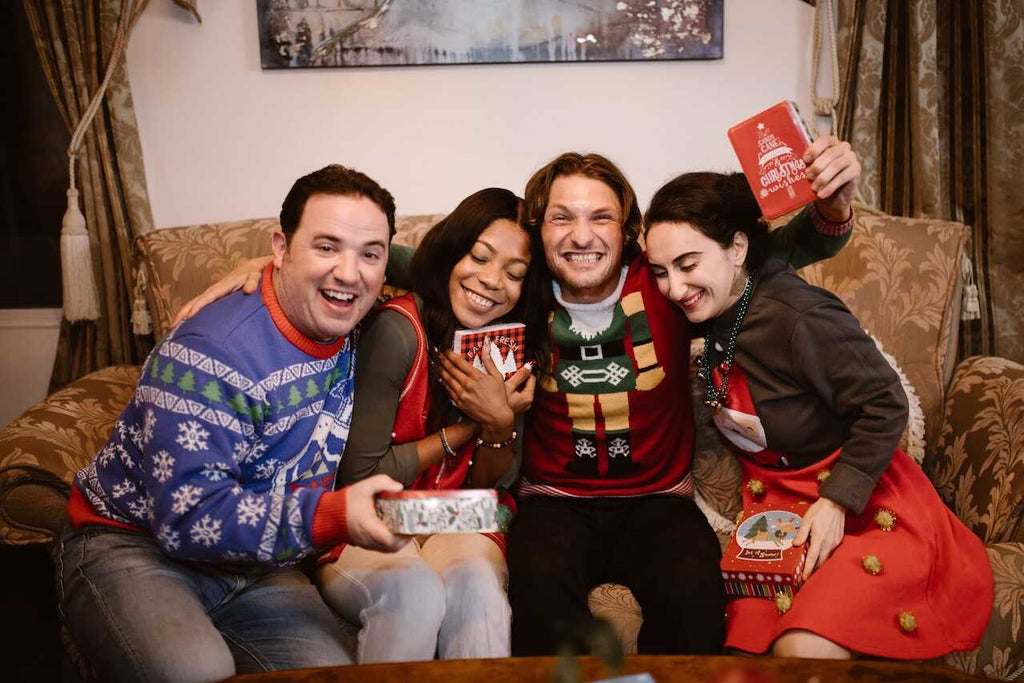 Four people wearing ugly sweaters for a Christmas party theme