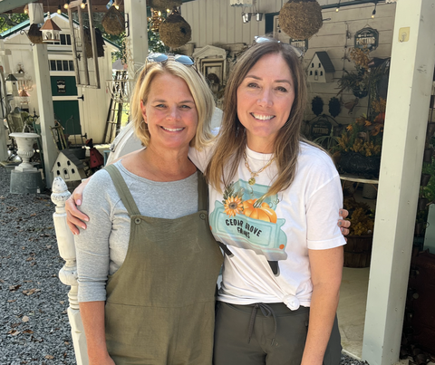 Two women standing in front of a store