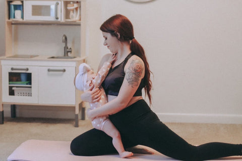 A new mom is breastfeeding her baby in Sweat and milk's Venice Nursing Sports Bra
