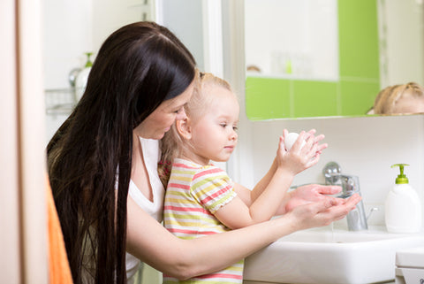 a mom is washing hands for her baby