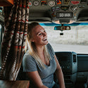 Author Katie Larsen sitting in the driver seat of her campervan