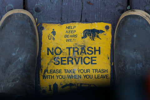 Bear warning sign between a pair of boots.