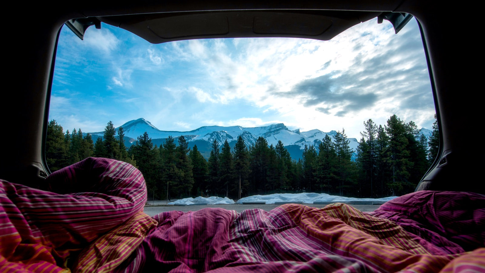Blankets inside a camper with a view of the outdoors