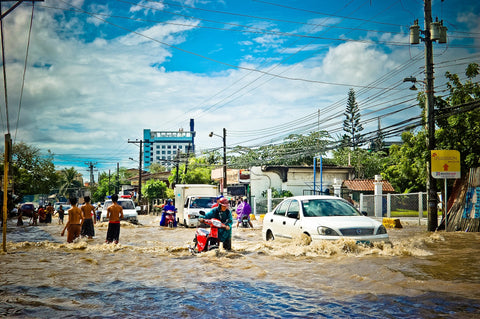 Flooded street with people walking through.