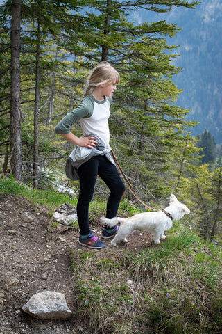 Girl with small dog on trail.