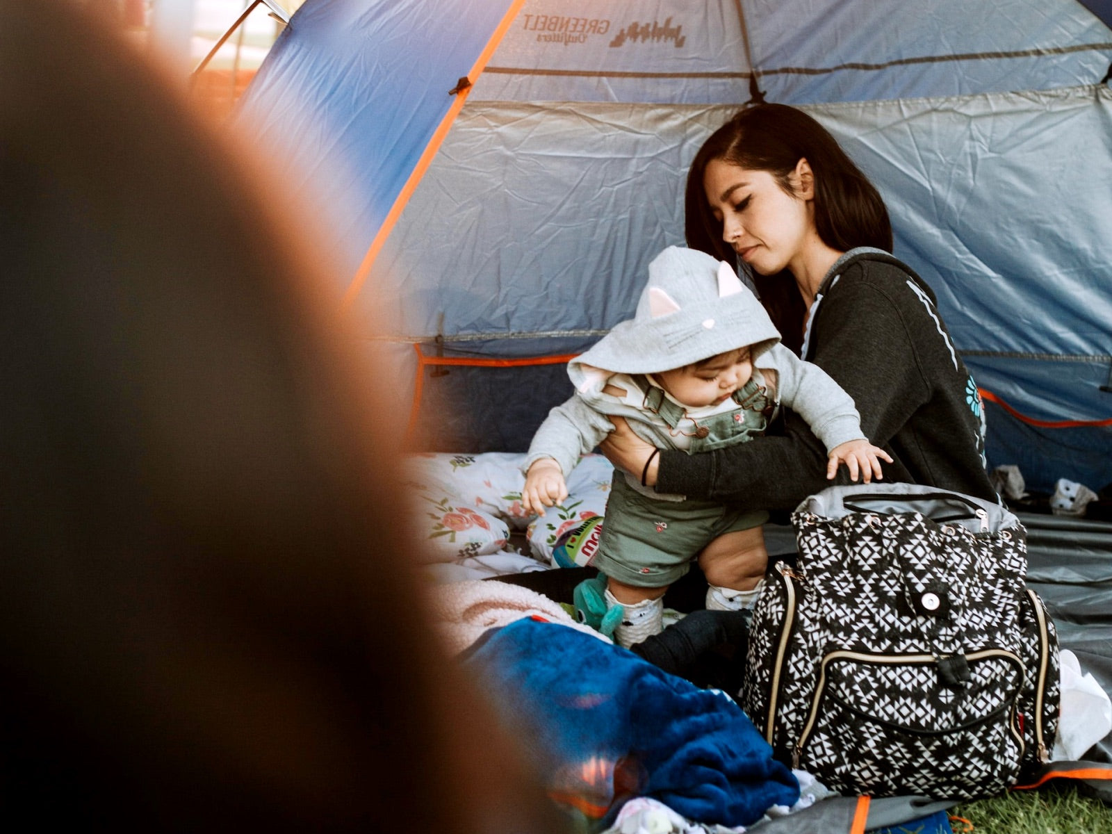 woman sitting in tent holding a baby