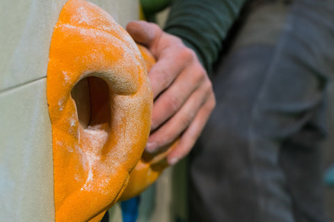 Close-up of a rock climber's hand griping a climbing hold.