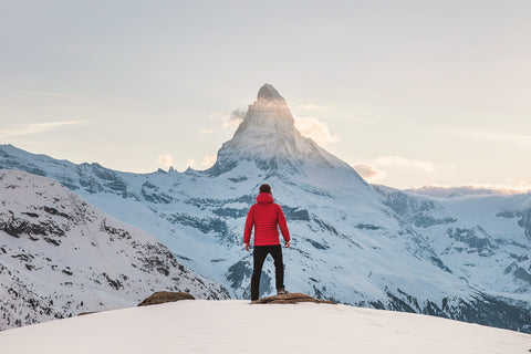 A man is looking at the top of a mountain peak.