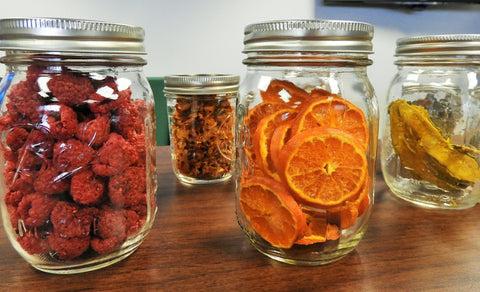 Mason jars of dried orange slices, raspberries & other fruit.