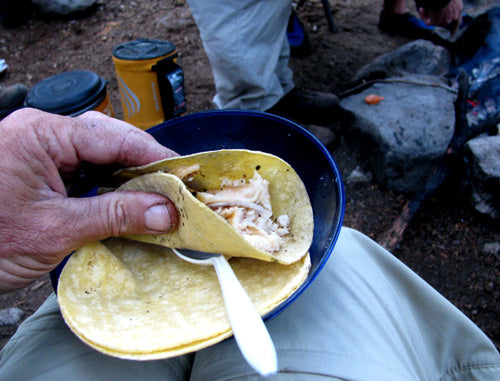hand holding trout taco at camp