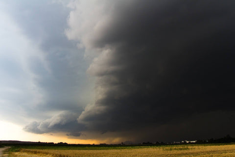 Dark storm cloud front over farm plains.