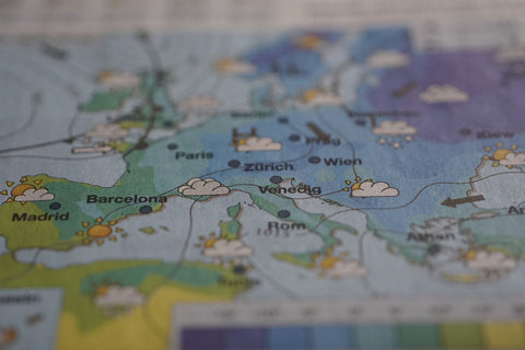 Paper map with weather forecast icons for European cities.