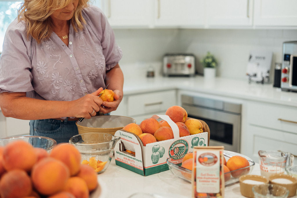 Michelle Sirles of Rendleman Orchards peels peaches for homemade peach cobbler