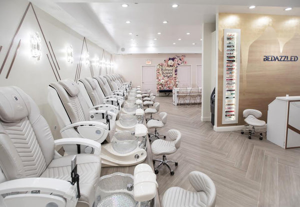 Bedazzled Nails in Chicago. White/grey whale spa chairs with a flower wall in the back.