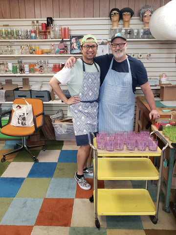 Egads co-owners Remy Darby and Jeff Ball pose in front of a display of vintage drinkware in their colorful studio, located in Toledo, Ohio.
