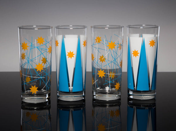 Eight-pointed, golden-yellow spark shapes interact with bright blue and white geometric shapes as they wrap around a quartet of drinking glasses.