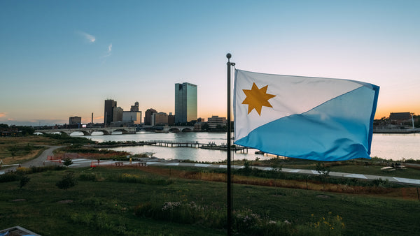The proposed Toledo flag is framed by the city's skyline at sunrise.