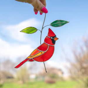 Stained glass red winter bird sitting on the branch suncatcher
